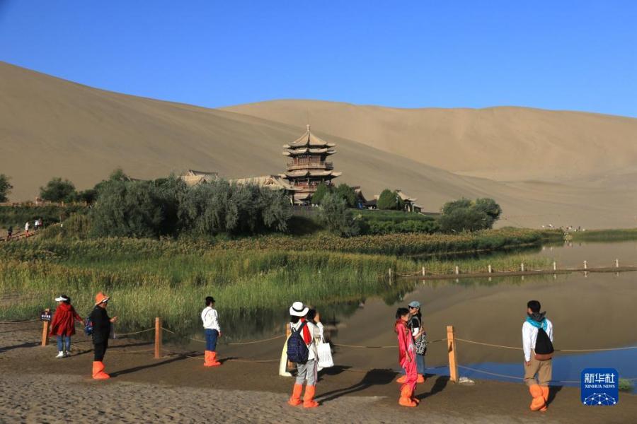 9月11日，游客在甘肃省敦煌市鸣沙山月牙泉景区游览。