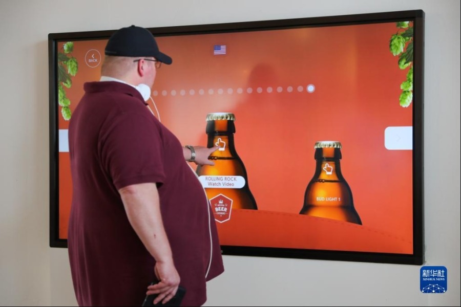 5月13日，一名游客在比利时布鲁日的“啤酒体验”博物馆使用互动屏幕了解啤酒知识。新华社记者 郑焕松 摄