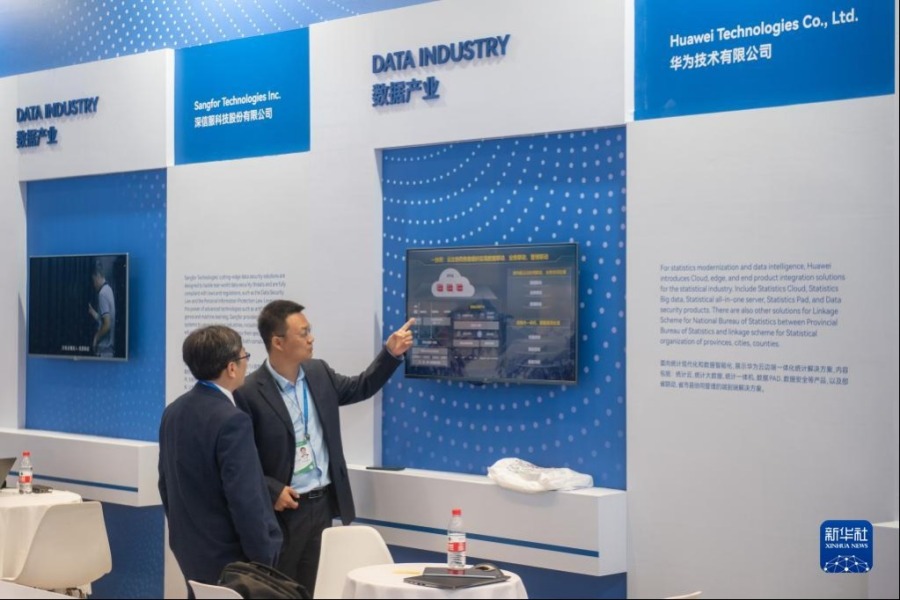 4月26日，在数据产业展区，华为技术有限公司代表（右）为参观者讲解。新华社记者 江汉 摄
