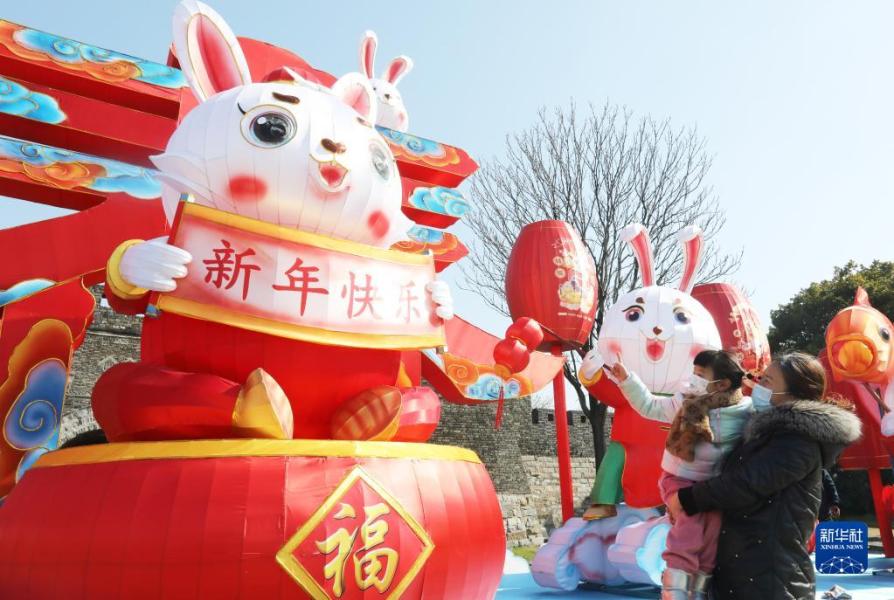 1月16日，在江苏省苏州市古胥门广场，小朋友在家长陪同下观赏彩灯“福兔迎春”。