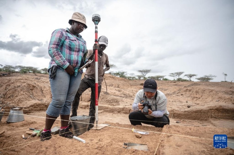 11月3日，中肯联合考古队队员娄文台（右）在位于肯尼亚巴林戈郡马里加特镇的考古现场拍摄发掘出的石器。新华社记者 王冠森 摄