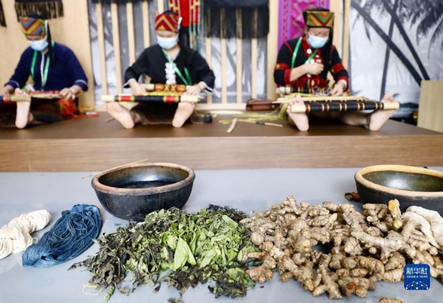 4月20日，在博鳌亚洲论坛主题公园内举办的“寻觅雨林·万物共生”热带雨林文化展上，黎族妇女使用纯天然染料染成的彩线织锦。