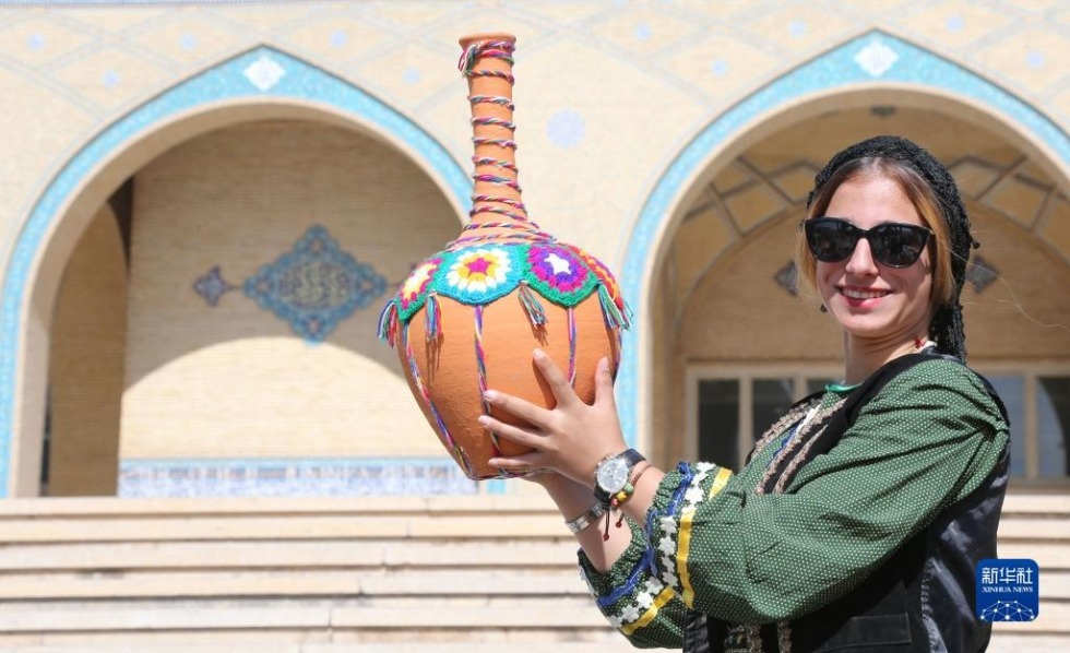 10月5日，在伊朗首都德黑兰，一名身着传统服饰的女子展示手工艺品。新华社记者 沙达提 摄