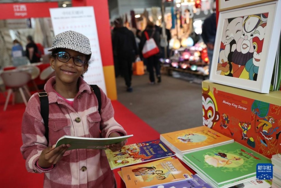 5月2日，在法国巴黎凡尔赛门展览中心举办的巴黎博览会上，儿童在“遇·鉴中国——中华文化主题展”上阅读“美猴王”系列英文版图书。新华社记者 高静 摄