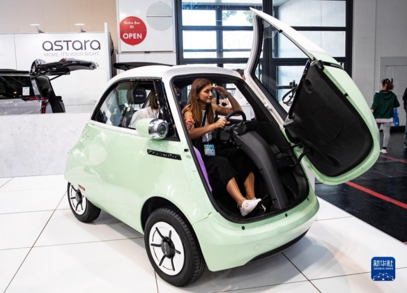 9月5日，在德国慕尼黑，人们在德国国际汽车及智慧出行博览会上体验一款小型新能源车。新华社记者 张帆 摄