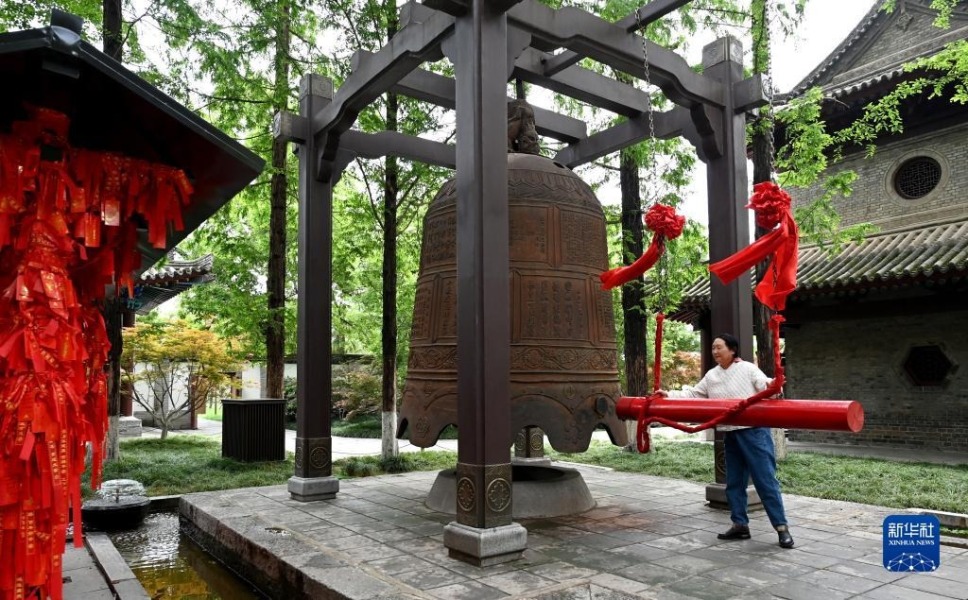 游客在西安荐福寺内敲钟祈福（5月8日摄）。荐福寺钟楼内的古钟与小雁塔曾一起形成了“关中八景”之一的“雁塔晨钟”。新华社记者 刘潇 摄