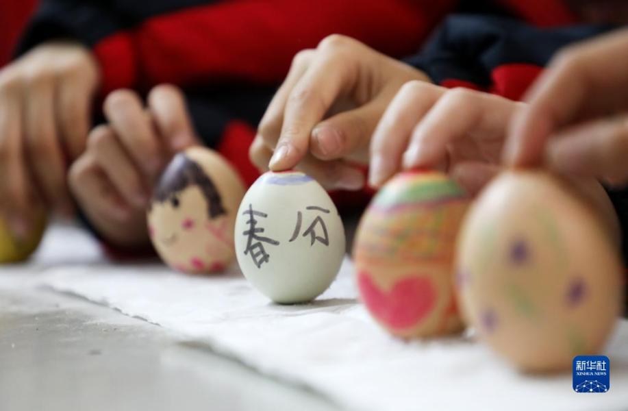 3月20日，在湖南省资兴市第一完全小学，孩子们在玩“立蛋”游戏。