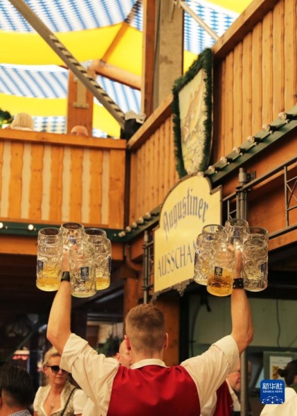 9月16日，工作人员在德国慕尼黑啤酒节上运送酒杯。新华社记者 张帆 摄