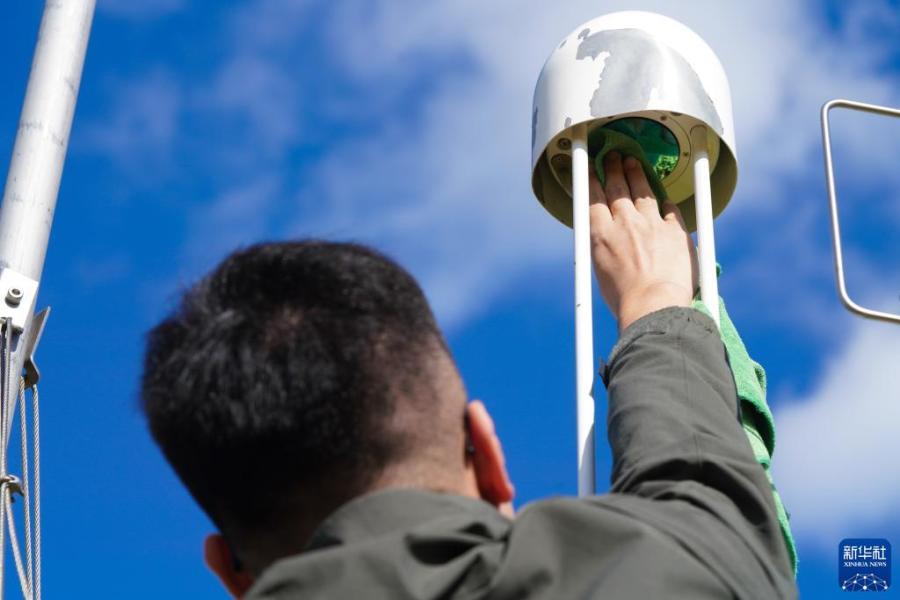 在富锦市现代农业万亩水稻科技示范园实验基地，气象员王国泰在维护农业气象观测仪器（9月22日摄）。