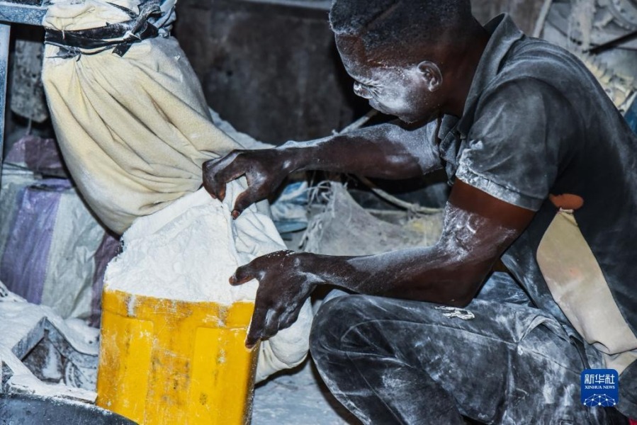 11月21日，在喀麦隆首都雅温得，一名男子用机器研磨木薯粉。新华社发（科普索摄）