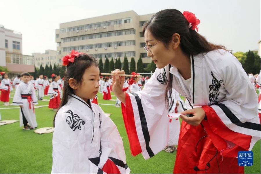 8月31日，安徽省淮北市黎苑路小学的老师在“开笔礼”仪式上为学生点朱砂。