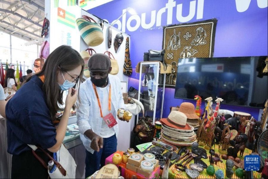 9月1日，在2022年服贸会首钢园区，参观者（左）在了解展出的多哥共和国商品。新华社记者 鞠焕宗 摄
