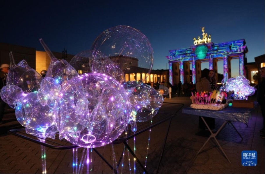 这是10月7日在德国柏林勃兰登堡门前拍摄的用彩灯装饰的气球。新华社发（斯特凡·蔡茨摄）