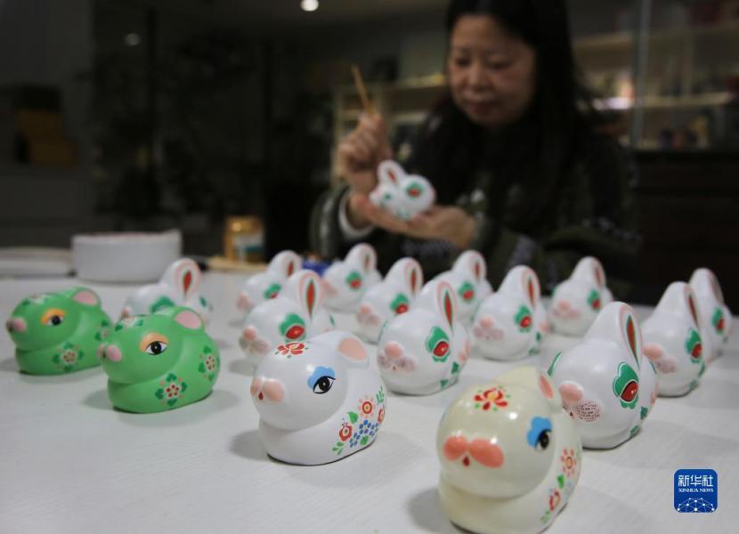 1月16日，江苏省无锡市民间艺人徐旦为生肖兔惠山泥人工艺品上彩。