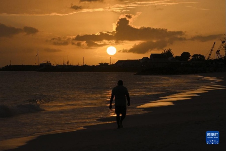 6月1日，一名男子走在巴巴多斯首都布里奇敦的一处海滩上。新华社记者 辛悦卫 摄