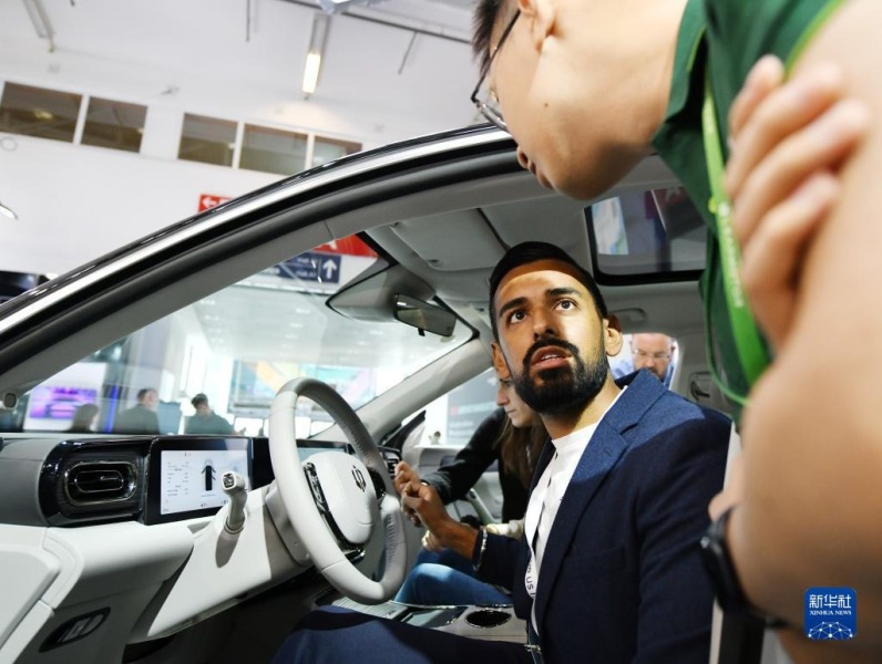 9月5日，在德国慕尼黑，参观者在德国国际汽车及智慧出行博览会的零跑汽车展区与工作人员交流。新华社记者 任鹏飞 摄