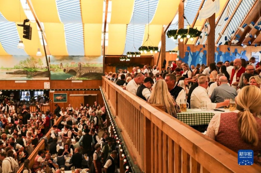 9月16日，人们在德国慕尼黑啤酒节上享用啤酒。新华社记者 张帆 摄