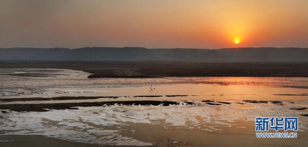 2月3日，黄河西岸的合阳黄河湿地自然保护区内，太阳缓缓升起（无人机照片）。　新华社发（赵晓罡 摄）