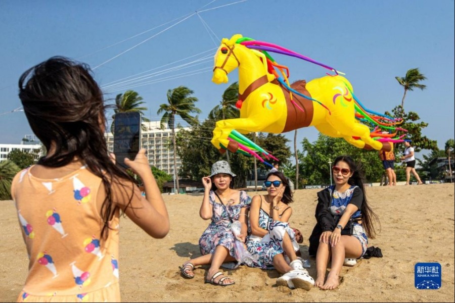 2月27日，游客在泰国芭提雅海滩与风筝合影。新华社记者 王腾 摄