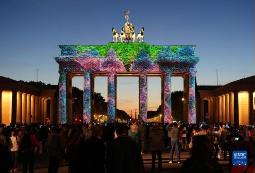 10月7日，德国柏林勃兰登堡门被灯光点亮。新华社发（斯特凡·蔡茨摄）