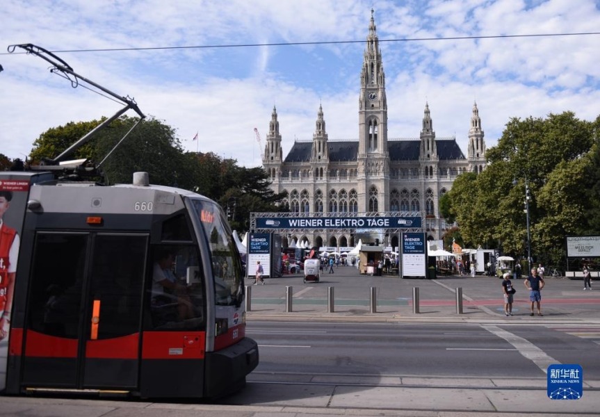 9月13日，一辆电车从奥地利维也纳电动汽车日活动现场前经过。新华社记者 贺灿铃 摄