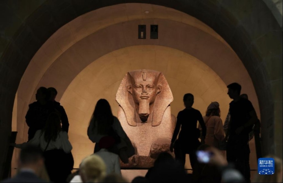 3月22日，在法国巴黎卢浮宫，人们穿过钟阁走进古埃及文物展厅。新华社记者高静摄