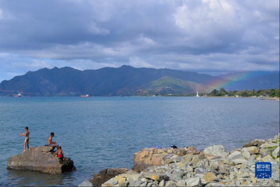 6月6日，在东帝汶首都帝力，一道彩虹出现在海边（无人机照片）。 新华社记者 徐钦 摄