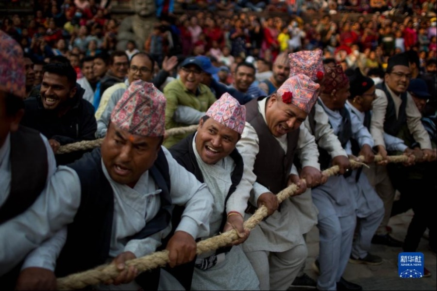 4月10日，在尼泊尔中部加德满都谷地的巴克塔普尔，参加新年庆典的人们在传统的庆祝活动上合力拖拽巨大的神像战车。新华社发（苏拉韦·什雷斯塔摄）